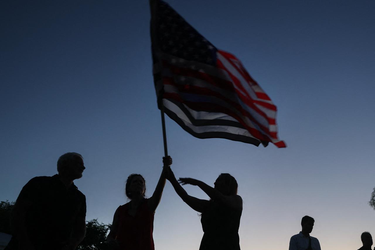 People pray during a vigil for Charlie Kirk outside the headquarters of Turning Point USA on September 19, 2025, in Phoenix, Arizona, U.S. on Sept. 19, 2025. (AFP Photo)
