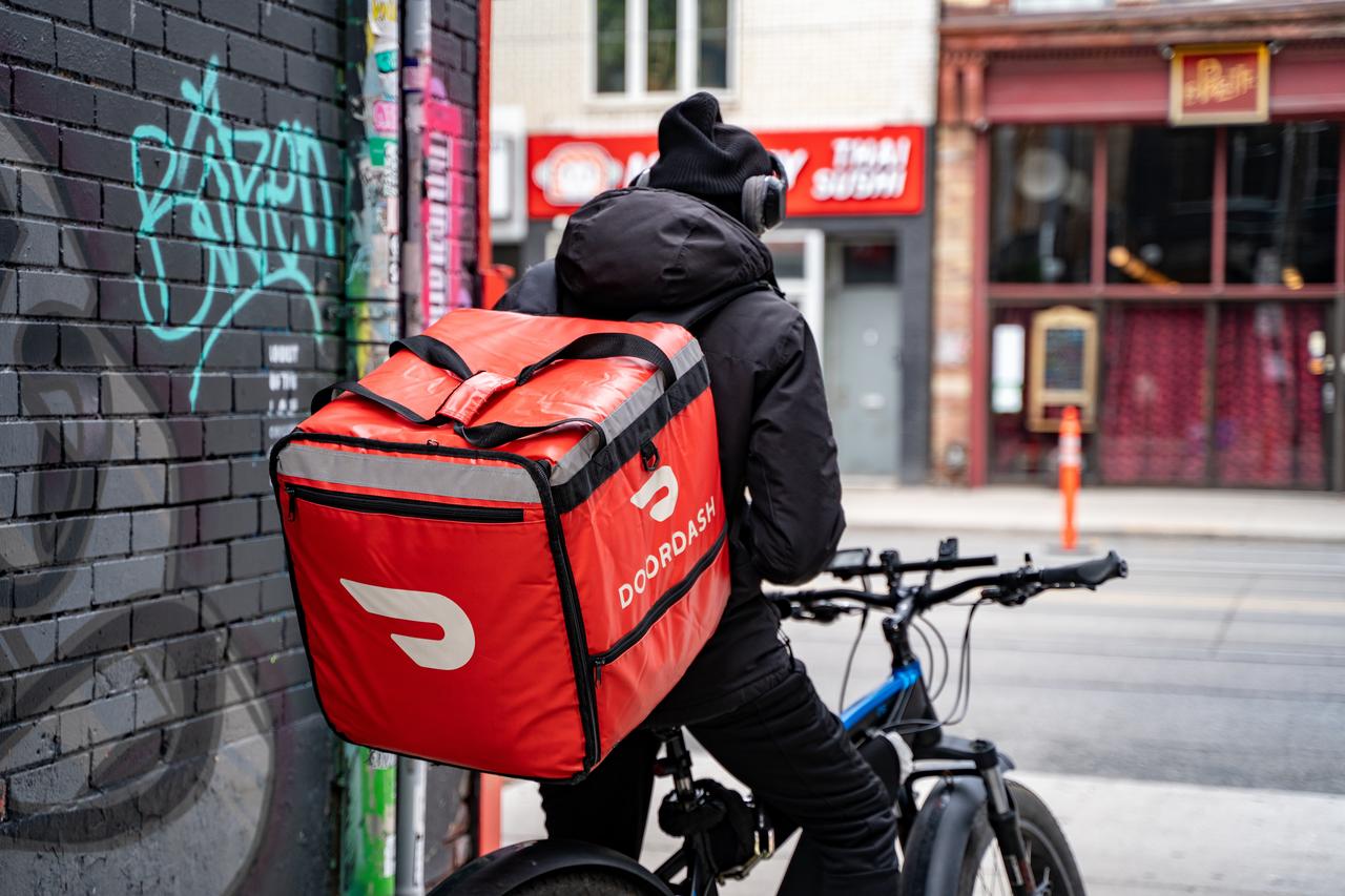 A DoorDash courier rides a bicycle while delivering food in Toronto, Canada, May 25, 2024. (Adobe Stock Photo)