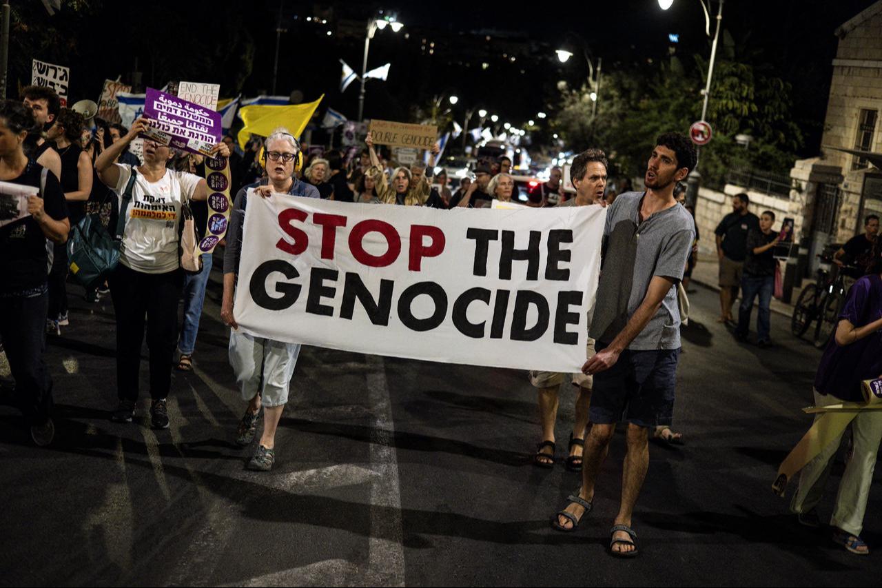 Protesters hold up a banner with ‘Stop the Genocide’ written on it during a demonstration against the war in Gaza and calling for release of hostages in Jerusalem, Sept. 20, 2025. (AFP Photo)