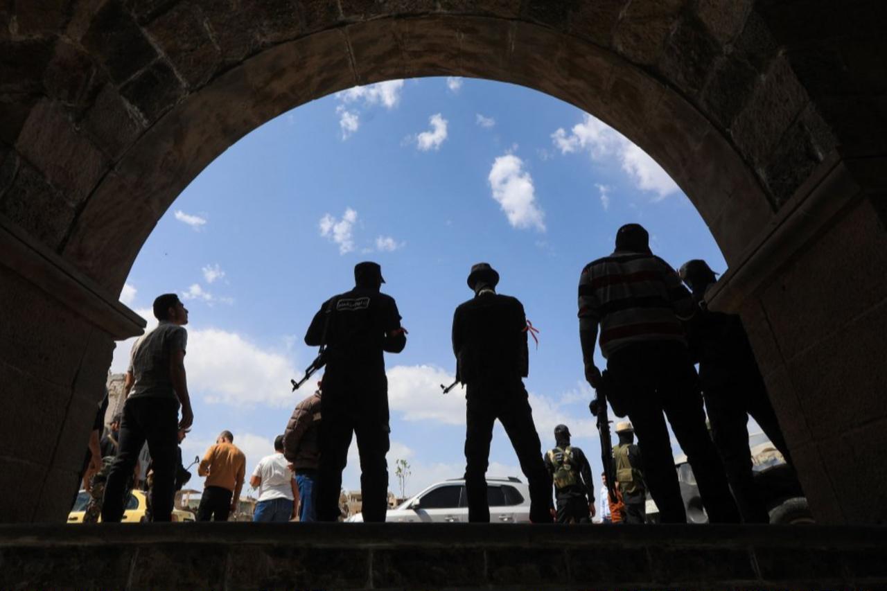 Members of Syrias security forces stand guard during the funeral of three people killed in Israeli strikes a day earlier, southern town of Daraa, Syria, March 18, 2025. (AFP Photo)