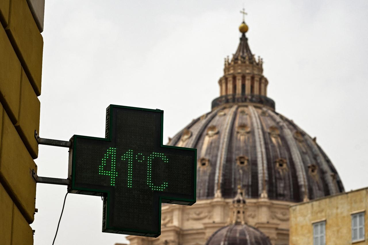 Pharmacy sign indicating the current outside temperature as 41 degrees celsius, with the dome of Saint Peter Basilica in the background, in Rome on June 21, 2024. (AFP Photo)