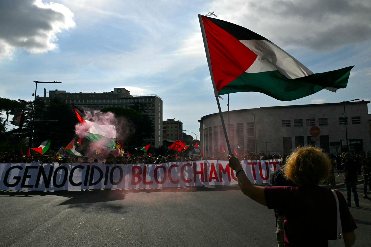 People march behind a banner reading  Against Genocide Lets block everything  during a nationwide strike in solidarity with Palestinians, in Rome, Sept. 22. (AFP Photo)