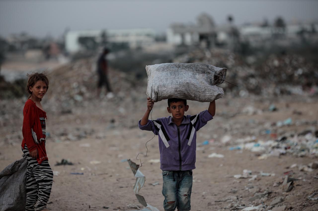 Children living in the city of Deir al-Balah in Gaza collect plastic and wood from piles of garbage to contribute to their families' livelihoods and meet their basic needs on Sept. 21, 2025. (AA Photo)