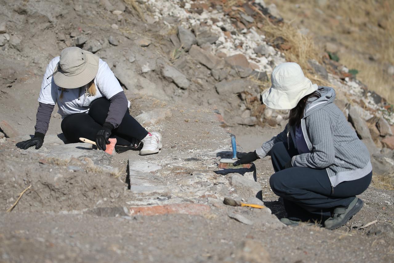 Araştırmacılar, 23 Eylül 2025, Türkiye'deki ANI'deki Selçuklu Period kazıları sırasında ortaya çıkan mimari kalıntıları inceliyor ve temizliyor. (AA fotoğrafı)