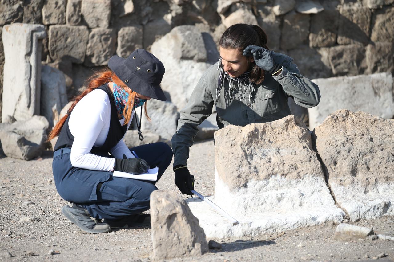 Ekip üyeleri, Kars, Türkiye, 23 Eylül 2025'teki ANI arkeolojik bölgesinde Selçuklu Mezarlar ve Mimari Parçaların Ölçümlerini kaydeder. (AA Photo)