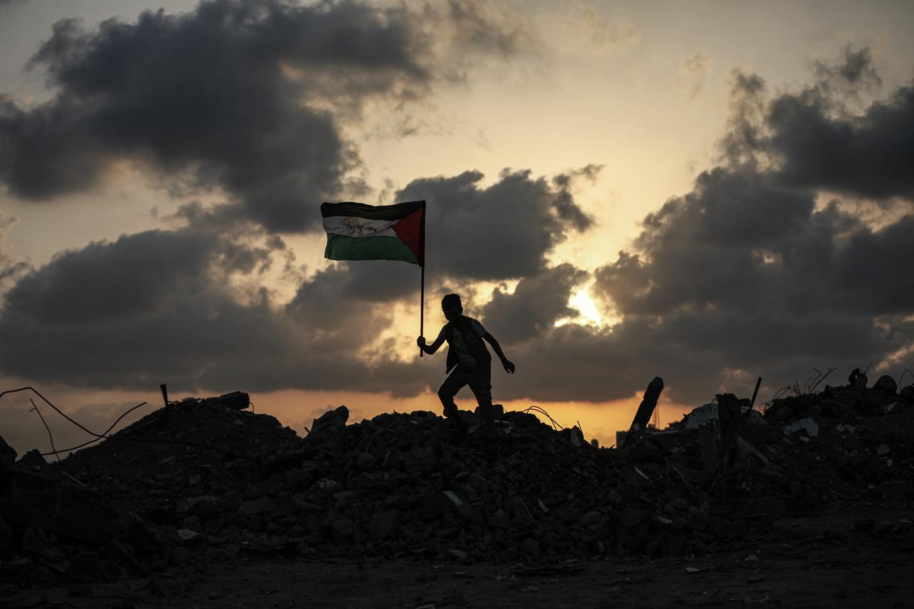 Group of Palestinian children in Bureyc Camp raise the Palestinian flag over the rubble of buildings destroyed by Israeli strikes following announcements of recognition of the State of Palestine by Canada, Australia, the UK, and Portugal in Gaza City, Gaza on Sept. 22, 2025. (AA Photo)