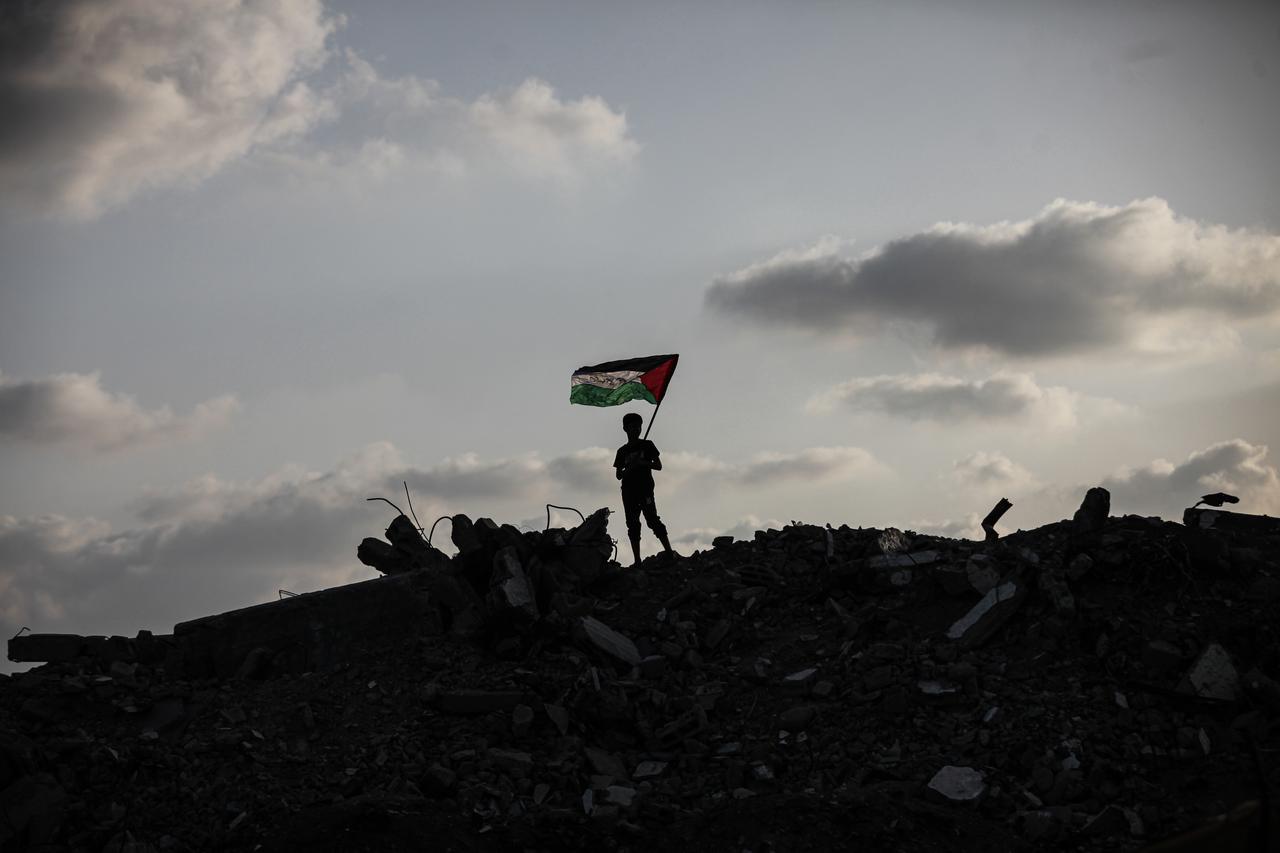 Group of Palestinian children in Bureyc Camp raise the Palestinian flag over the rubble of buildings destroyed by Israeli strikes following announcements of recognition of the State of Palestine by Canada, Australia, the UK, and Portugal, on Sept. 22, 2025. (AA Photo)