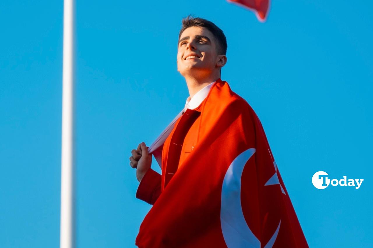 Omar Aliyev wrapped in a Turkish flag, smiling under the clear sky. (Photo via Omar Aliyevs archive)