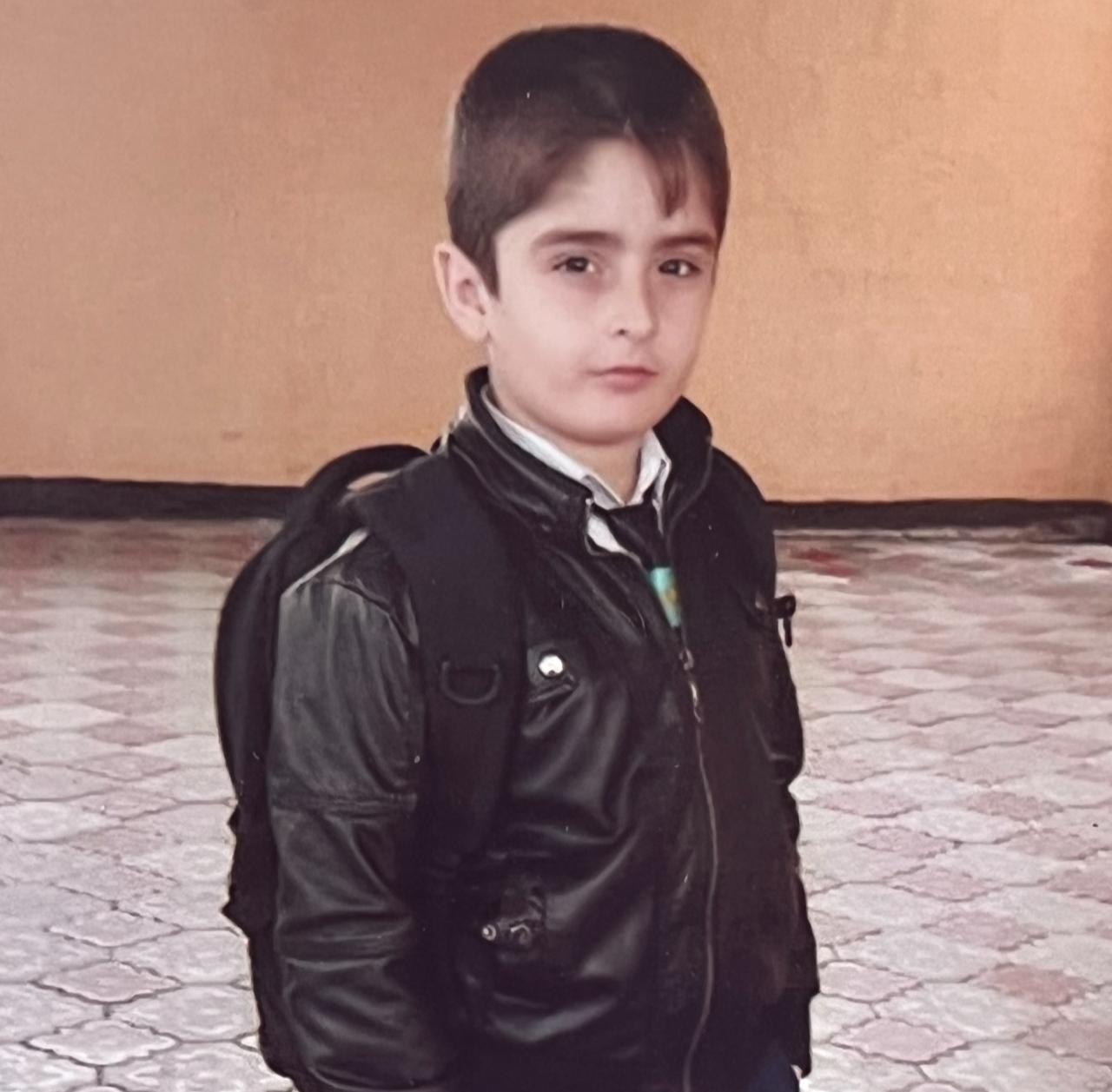 A childhood photo of Omar Aliyev wearing a school uniform and leather jacket. (Photo via Omar Aliyev's archive)