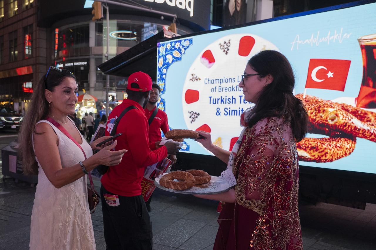 Visitors receive simit, a staple of Turkish breakfast, during the Anadoludakiler project promotion at Times Square in New York, US, Sept. 24, 2025. (AA Photo)