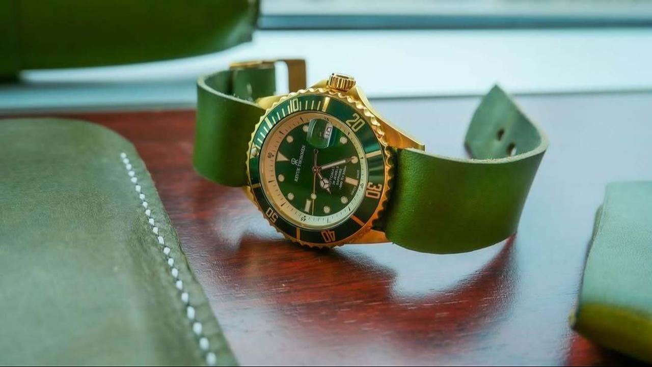 A Swiss luxury watch with a green dial and strap displayed on a wooden surface. (Photo via Instagram/@stylishindian.co)