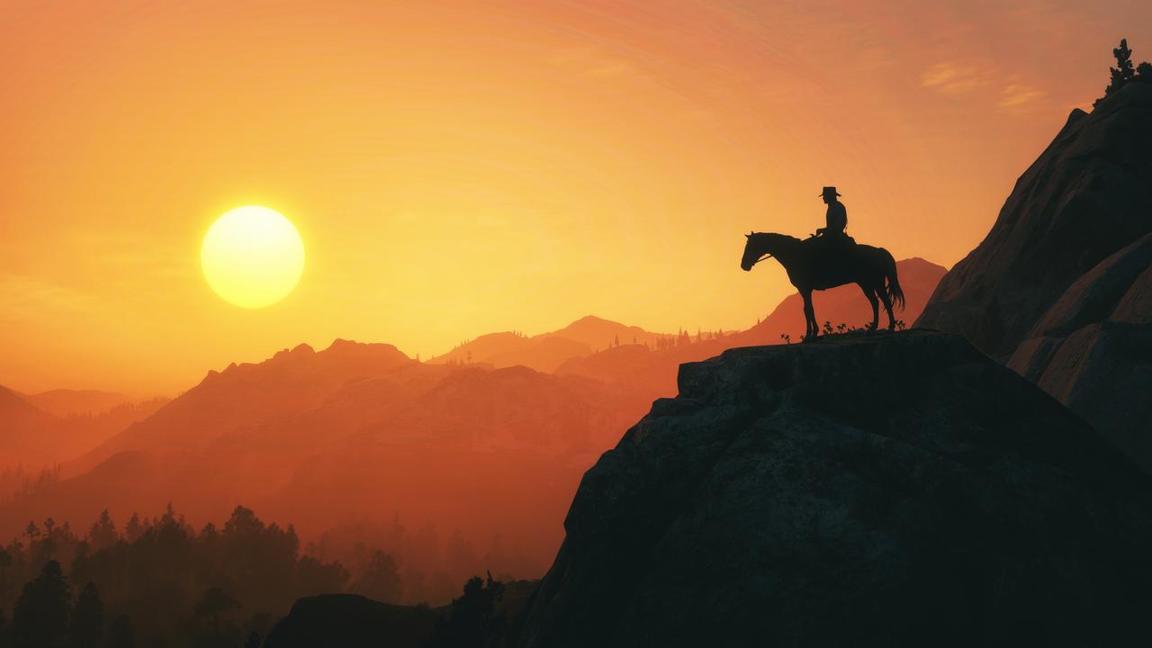 Silhouette of a cowboy on a horse from Red Dead Redemption 2, standing on a mountain top at sunset with orange golden hour tones, sun, and scattered clouds, accessed Sept. 24, 2025. (Adobe Stock Photo)
