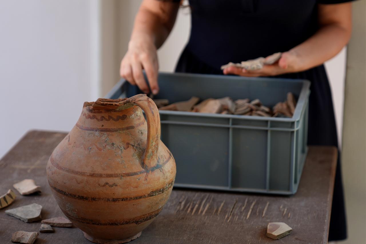 Researchers examine pottery fragments found at the 5,000-year-old Smyrna Hoyuk excavation site in Izmir, Türkiye, Sept. 15, 2025. (AA Photo)