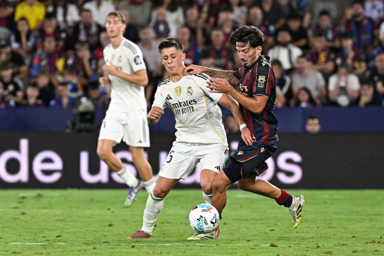 Real Madrid's Turkish midfielder Arda Guler fights for the ball with Levante's Spanish midfielder Unai Vencedor during the Spanish league football match between Levante UD and Real Madrid CF at the Ciutat de Valencia stadium in Valencia, Spain, September 23, 2025. (AFP Photo)