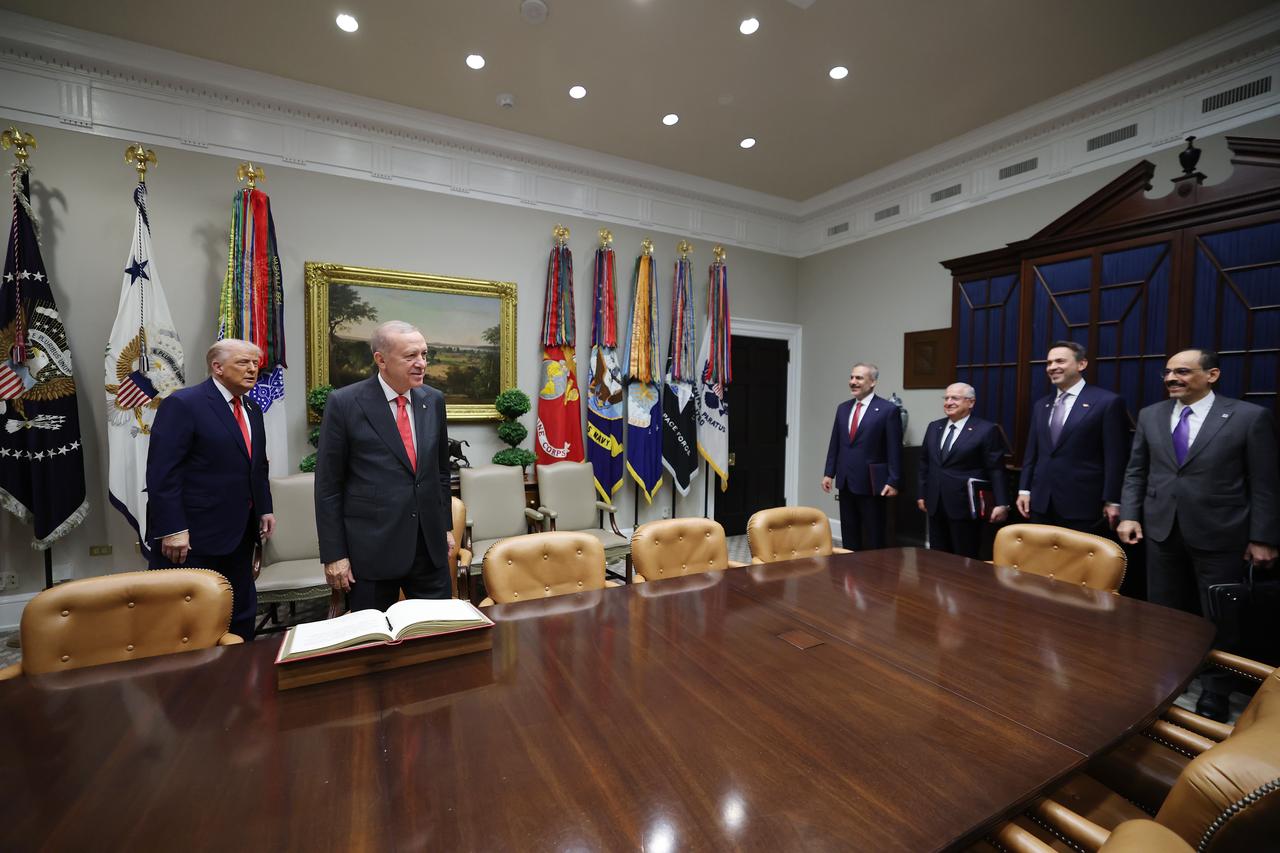 Turkish President Recep Tayyip Erdogan (R) signs the guestbook at the White House before holding bilateral talks with U.S. President Donald Trump (L) in Washington, U.S. on Sept. 25, 2025. (Turkish Presidency / AA Photo)