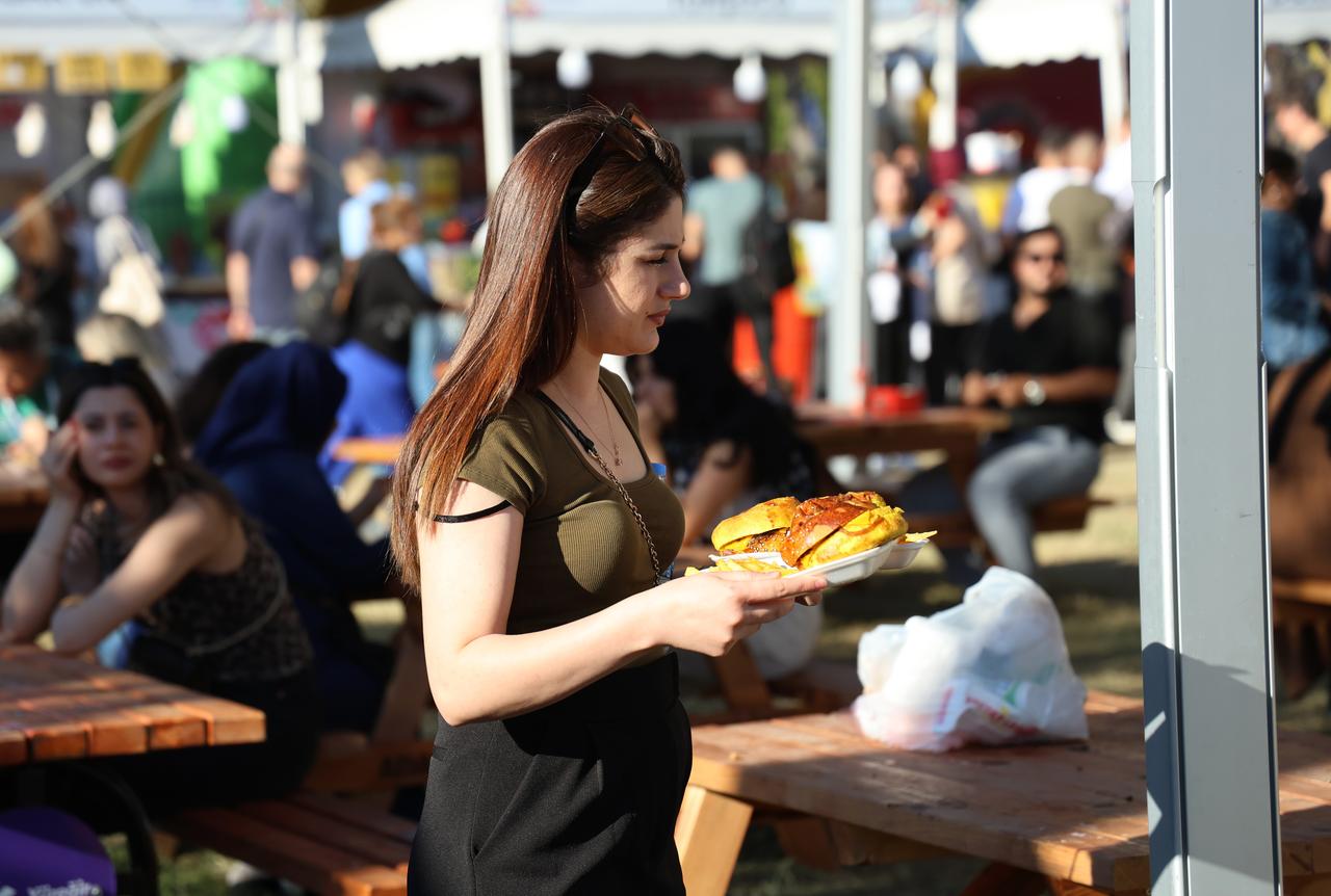 A visitor carries a plate of festival food at the 8th International Taste of Adana Festival in Adana, Türkiye, Oct. 18, 2024. (IHA Photo)