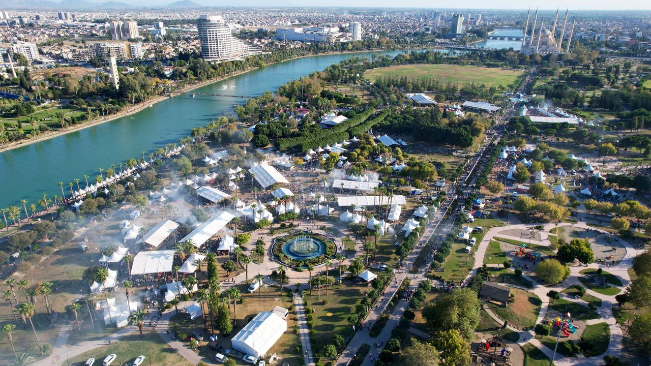 An aerial view shows Merkez Park and the Seyhan River hosting the 8th International Taste of Adana Festival in Adana, Türkiye, Oct. 18, 2024. (IHA Photo)