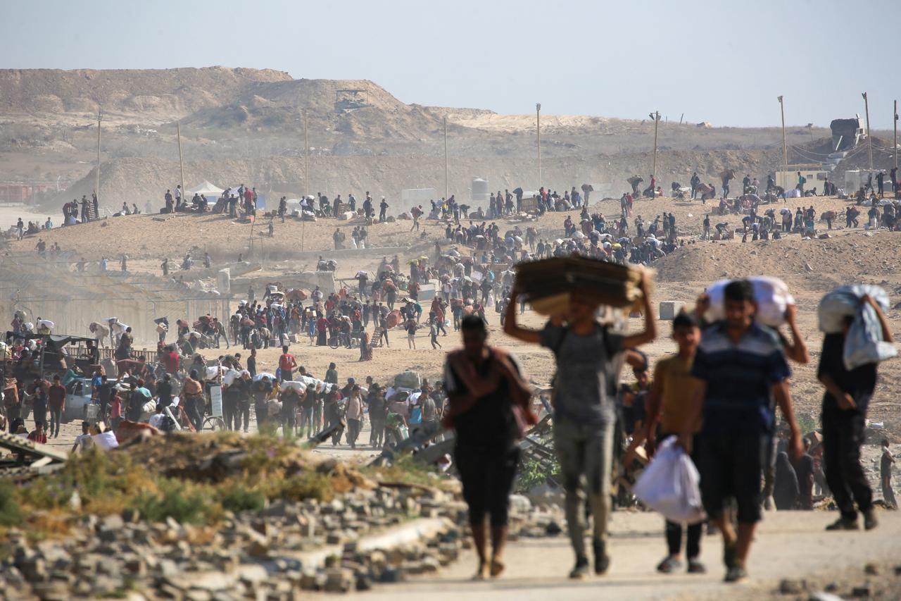 People walk with bags of humanitarian aid they received at a distribution centre run by GHF, at so-called  Netzarim corridor , in central Gaza Strip, Sept. 26, 2025. (AFP Photo)