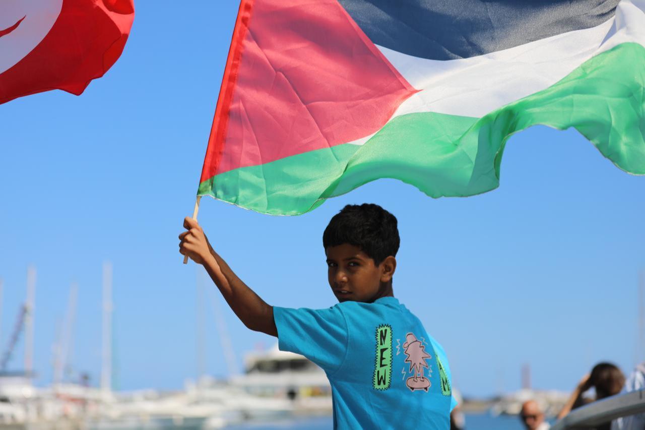 Tunisian boy waves the Palestinian flag to show his support at the port of Bizerte to show their support as the Global Sumud Flotilla docks in northern Tunisia, Sept. 12, 2025. (AA Photo)