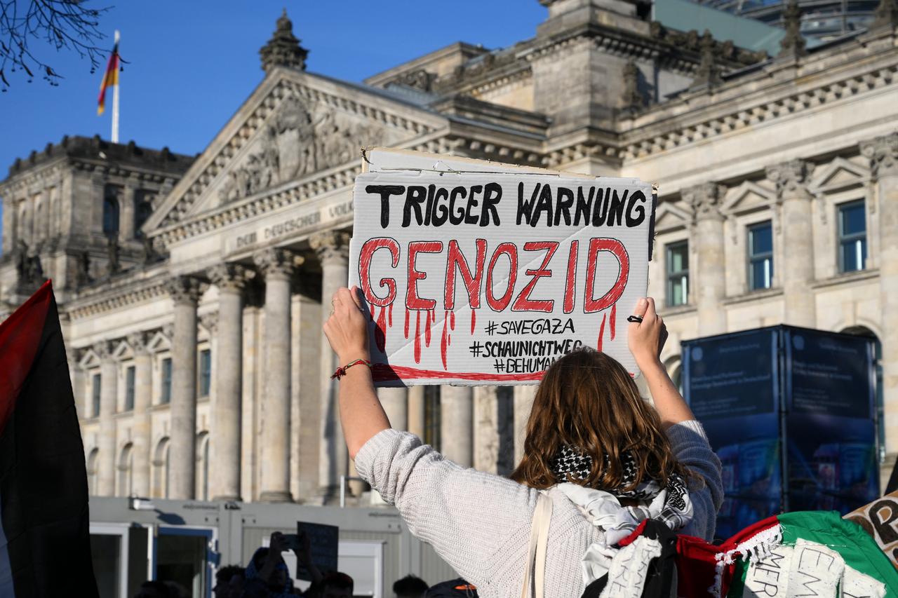 Bir katılımcı, 'Kırmızı Çizgiyi Bizimle Çizin: Gazze için Birlikte!' Reichstag Binasının önünde, 27 Eylül 2025'te Berlin'in merkezinde Alman Parlamentosu Federal Meclisi'ni barındıran. (AFP Fotoğrafı)