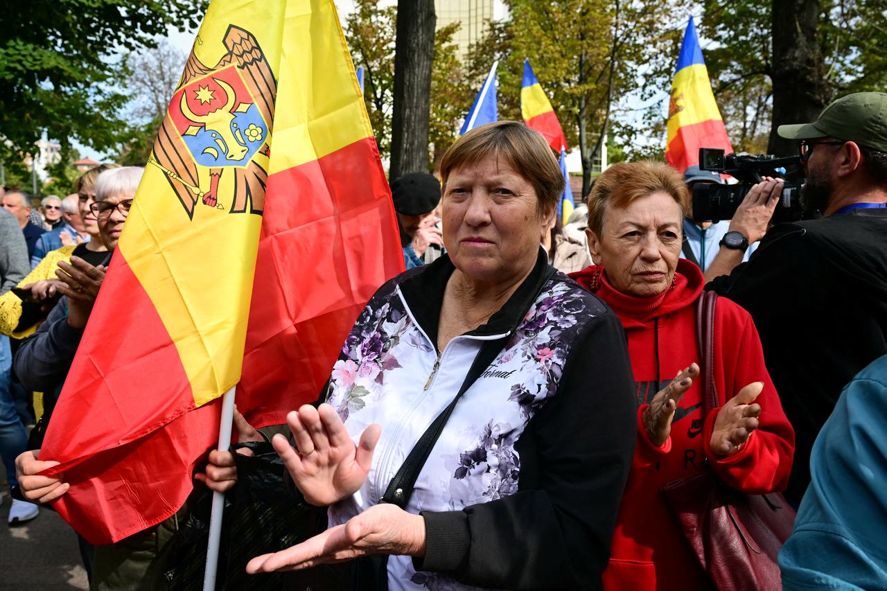 Protesters applaud and hold Moldovan flags as they take part in a demonstration organised by the opposition Patriotic Bloc party outside the Moldovan Parliament in Chisinau, on Sept. 29, 2025. (AFP Photo)