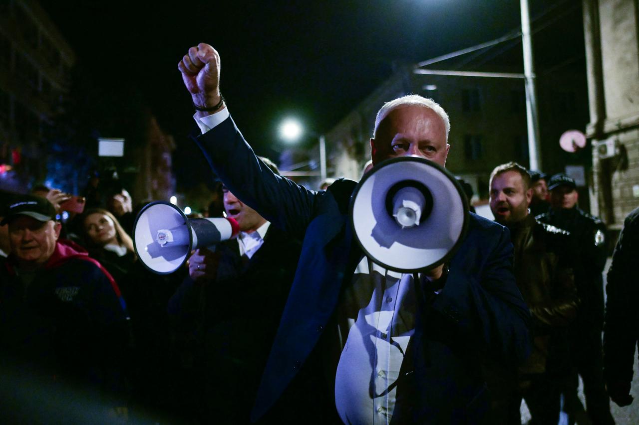 Igor Dodon, the leader of Socialist Party, uses a megaphone to address a small gathering of protesters in front of the Central Electoral Commission (CEC) alleging electoral fraud as votes continue to be counted, in Chisinau, Moldova on Sept. 28, 2025. (AFP Photo)