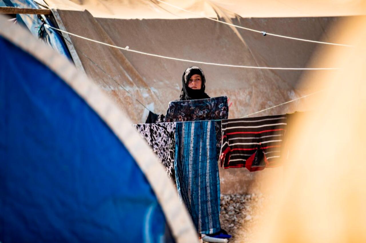 A Syrian woman, displaced from Ras al-Ain hangs laundry to dry between tents in Washukanni camp in northeastern Syrias al-Hasakah, November 12, 2020. (AFP Photo)
