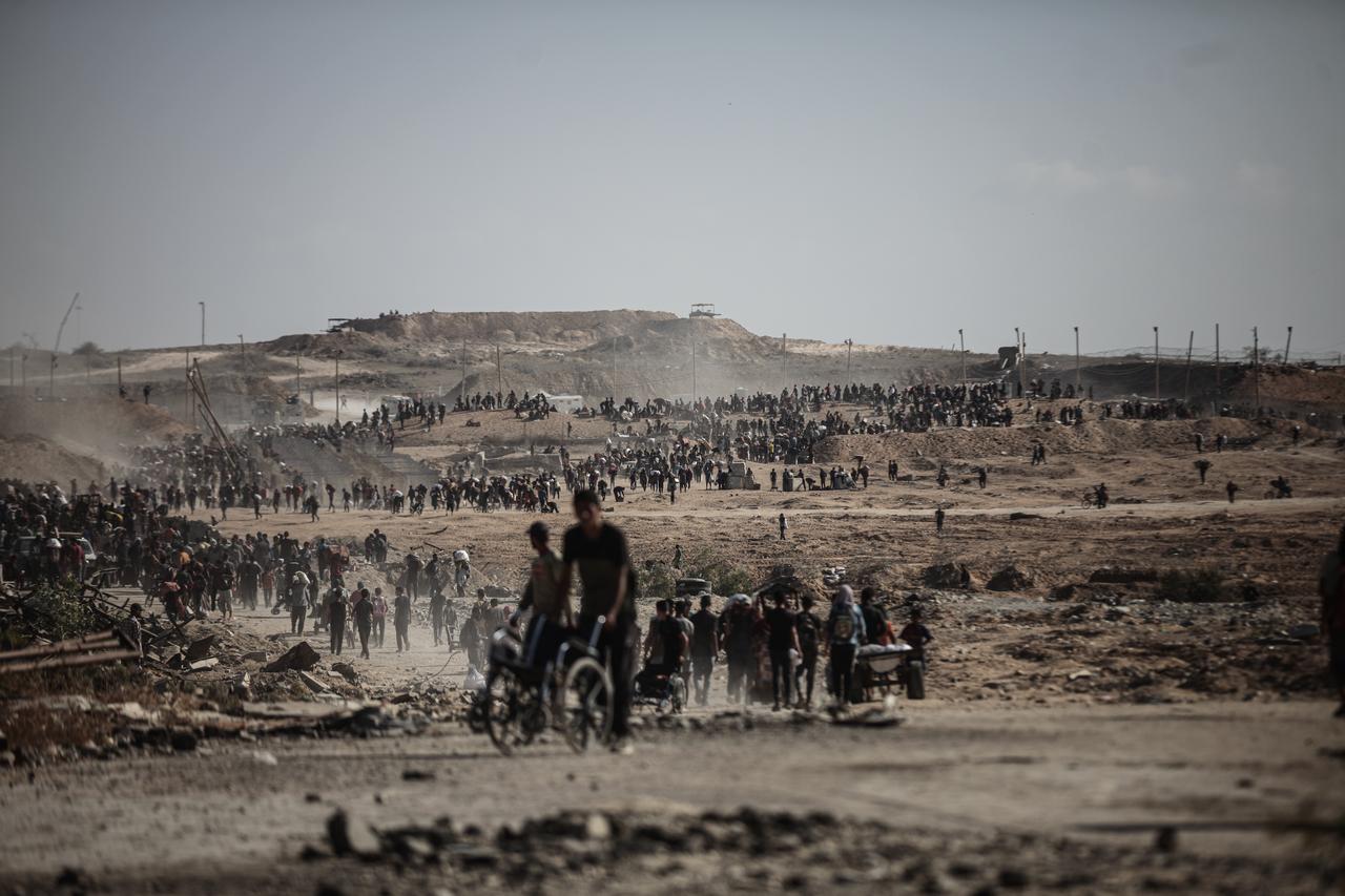 Palestinians carry food supplies back to their tents after risking their lives to reach an aid distribution point in the Netzarim area, as severe hunger continues in Gaza City, Gaza, Sept. 30, 2025. (AA Photo)