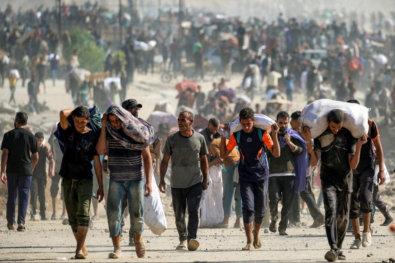 People walk with humanitarian aid packages that they received from a distribution centre at so-called "Netzarim corridor", in Nuseirat in Gaza Strip, Sept. 30, 2025. (AFP Photo)