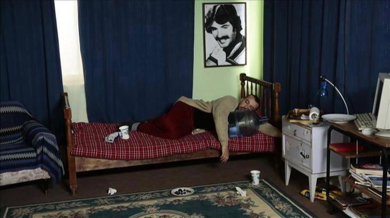 The main character of the popular Turkish comedy series Leyla ile Mecnun is lying in front of a portrait of Arabesk music legend Ferdi Tayfur. (Photo via X)