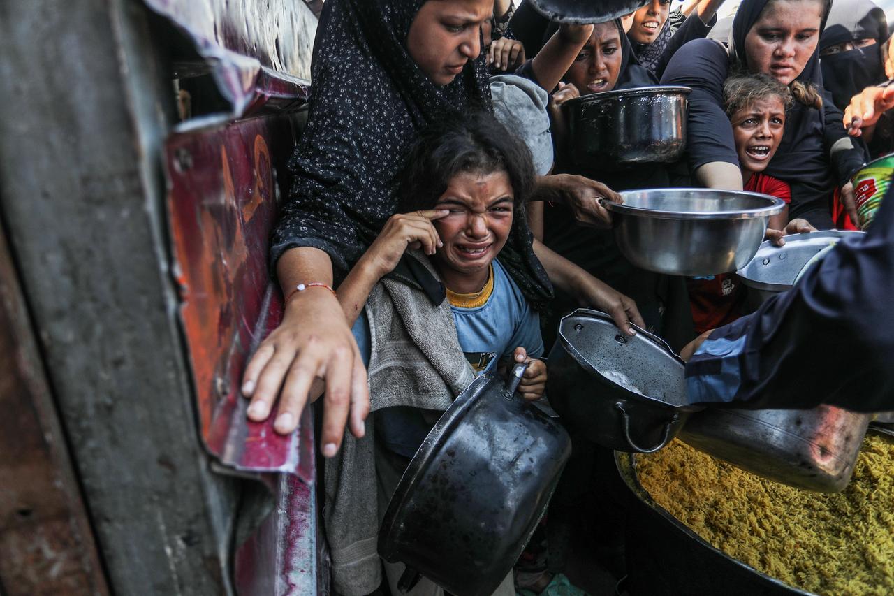 A girl is crying while holding an empty pot in her hand as Palestinians, who are struggling to access food due to Israel's embargo and ongoing attacks on the Gaza Strip, gather in order to receive hot meals distributed by a charity organization in the tent city where displaced Palestinians are staying in the Al-Mawasi area of Khan Yunis, Gaza on September 05, 2025. (AA Photo)