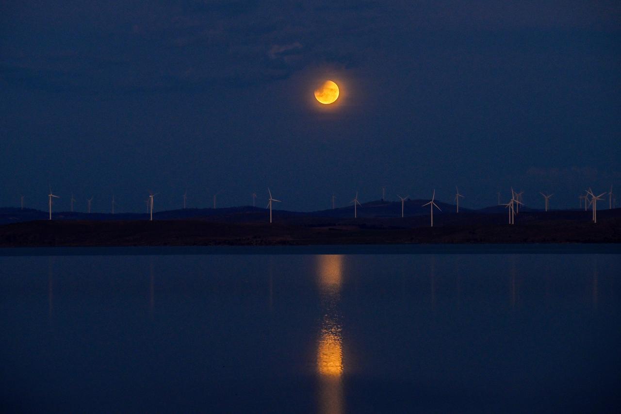 A full moon, also known as the "Blood Moon," is seen during a partial eclipse in the sky over Lake George near the Australian capital city of Canberra on March 14, 2025. (AFP File Photo)