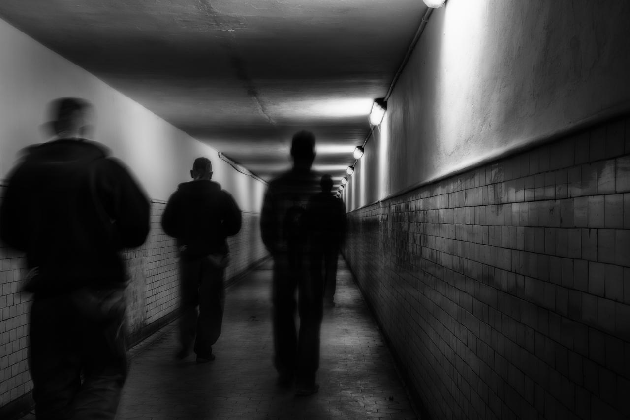 The photo shows a group of people walking in a tunnel at an unknown location and date. (Adobe Stock Photo)
