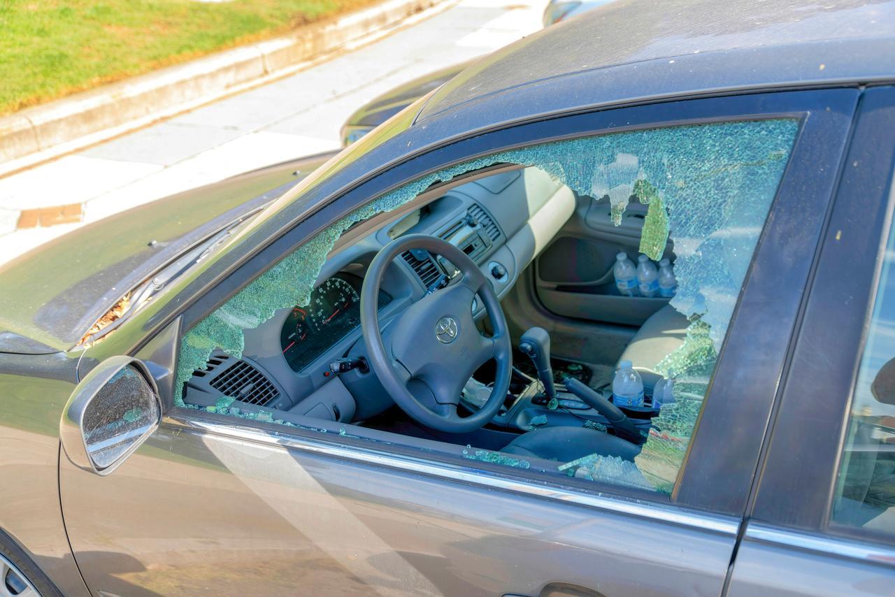Private gray car with shattered windows due to robbery and vandalism in San Francisco, California,  October, 2021. (Adobe Stock Photo)
