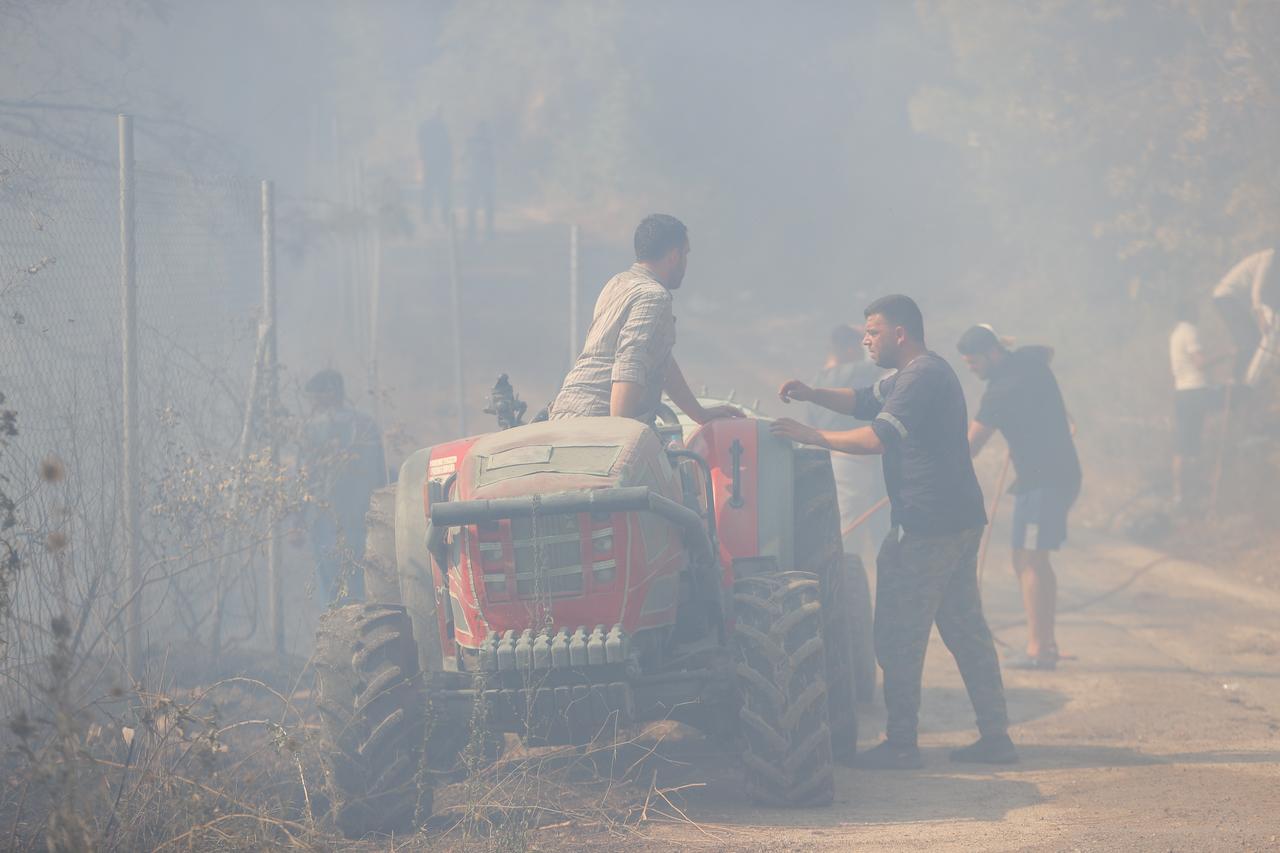Local residents and farmers are supporting firefighting efforts with water tankers as smoke from the fire area fills the sky while firefighters and Turkish General Directorate of Forestry teams continue their efforts to extinguish the fire that broke out in the forest area in Osmangazi district of Bursa, Türkiye on Sept. 05, 2025. (AA Photo)
