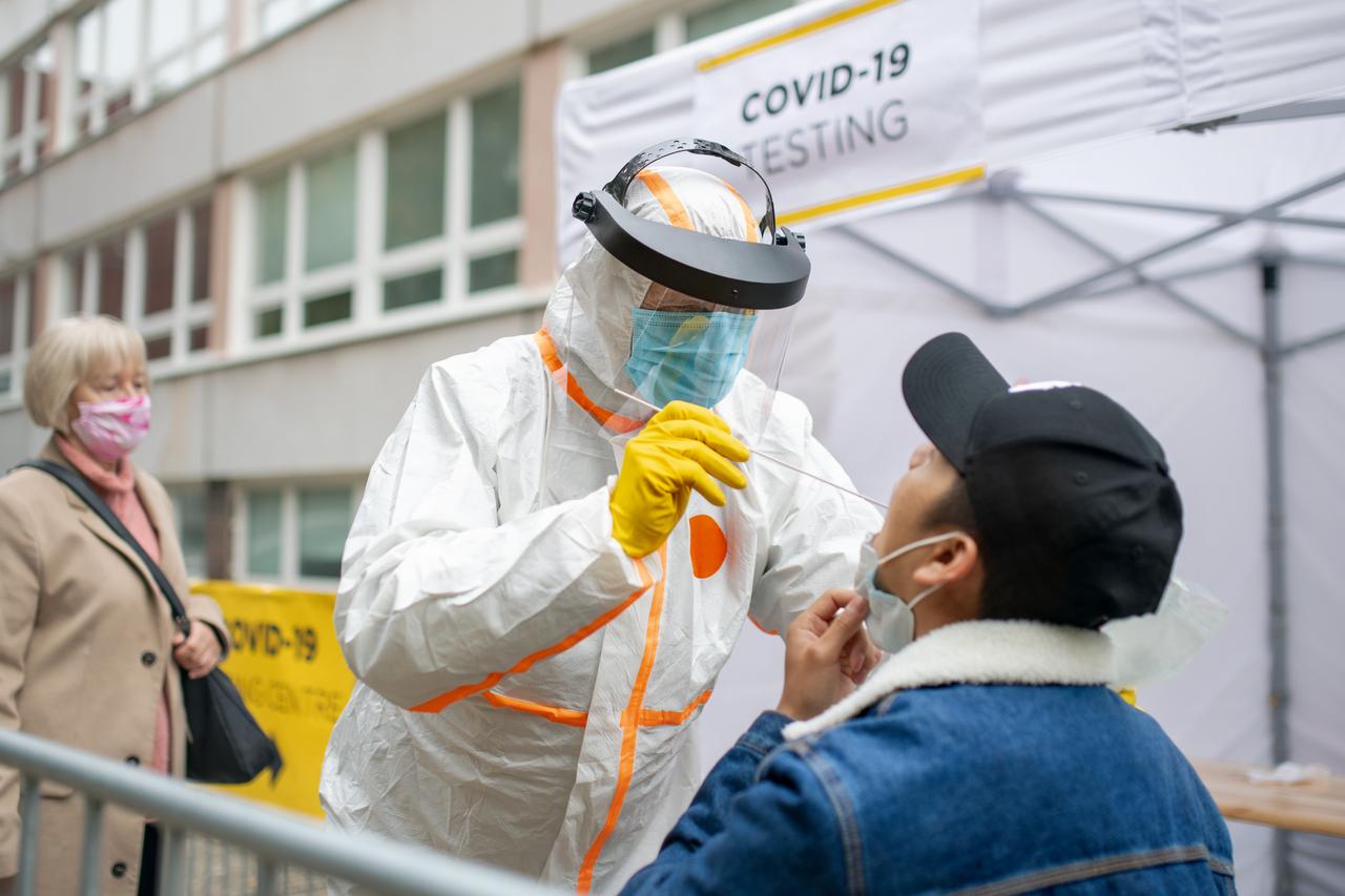 Man getting tested for COVID-19 at an outdoor street testing center. (Adobe Stock Photo)