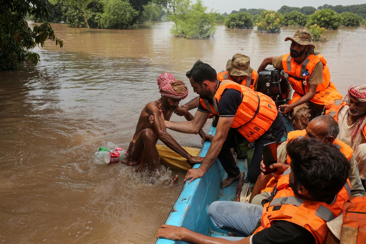 A rescuer helps a flood-affected man onto a boat following flooding of the Chenab River in Muzaffargarh, Punjab, Pakistan, September 6, 2025. (AFP Photo)