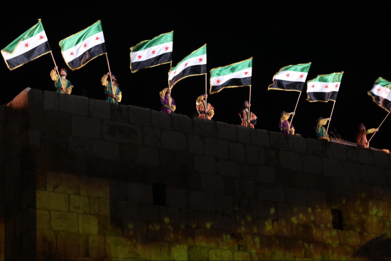 People wave flags of Syria as they attend the launch of the Syria Development Fund at the Damascus Castle in Syria, Sept. 4, 2025. (AA Photo)