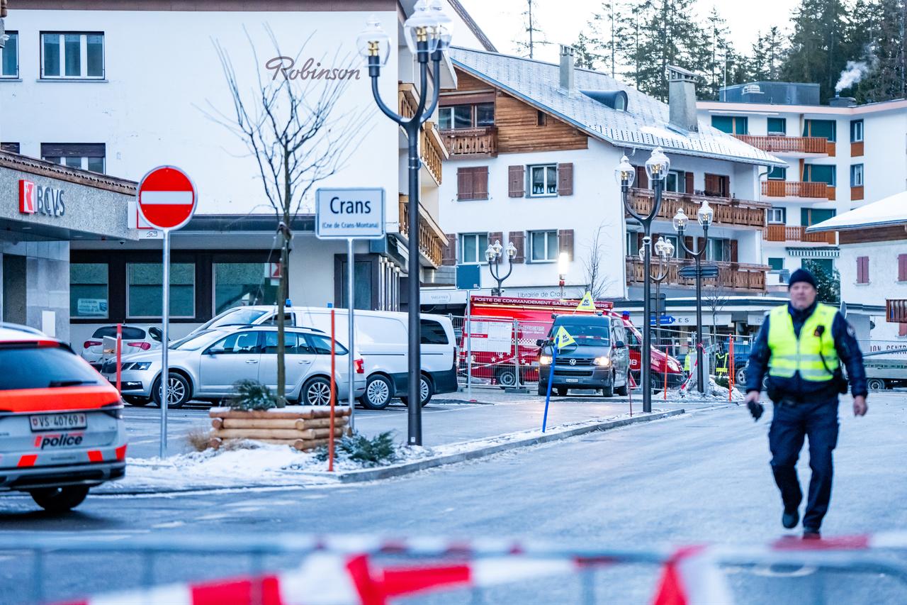 A police officer walks near ambulances at the site of an explosion that ripped through a bar in Crans-Montana on January 1, 2026. (AFP Photo)