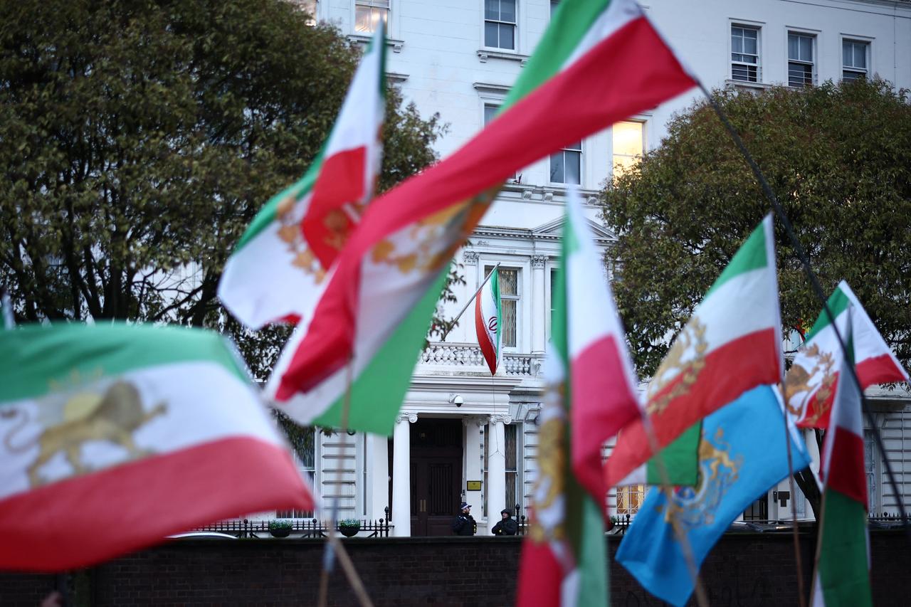 Anti-Iranian regime protesters wave the Iranian flag before the 1979 revolution with the Lion and Sun emblems during a gathering outside the Iranian Embassy, central London, on Jan. 9, 2026. (AFP Photo)