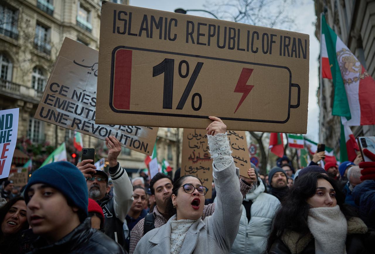 A protestor carries a placard depicting a battery with 1% charge with a message reading  "Islamic Republic of Iran" during a demonstration to support mass rallies denouncing the Islamic republic in Iran in Paris on Jan. 11, 2026. (AFP Photo)