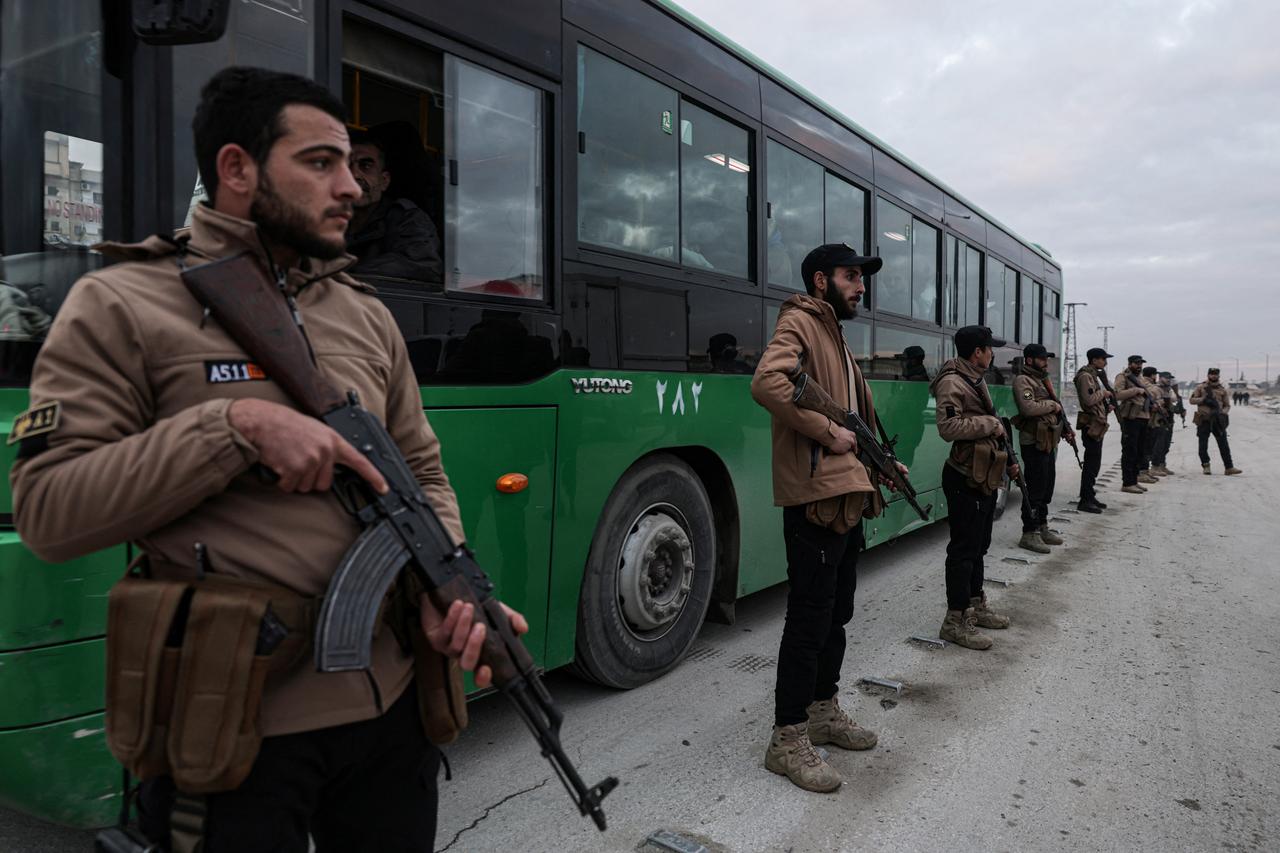 Syrian government forces stand guard over detained SDF members being escorted to detention centers, following clashes in the city of Aleppo, Syria on January 10, 2026. (AFP Photo)