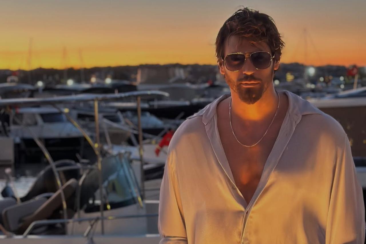 Can Yaman poses in front of a marina in Italy during sunset, Aug. 23, 2025. (Photo via Instagram/@canyaman)