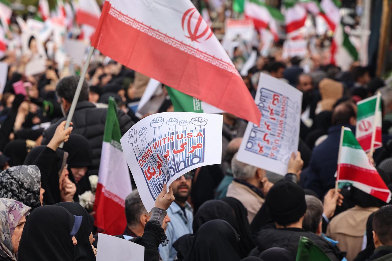 Iranians wave national flags and hold placards reading "Down with USA" during the funerals of security forces personnel killed in recent protests in Tehran, Jan. 14, 2026. (AFP Photo)
