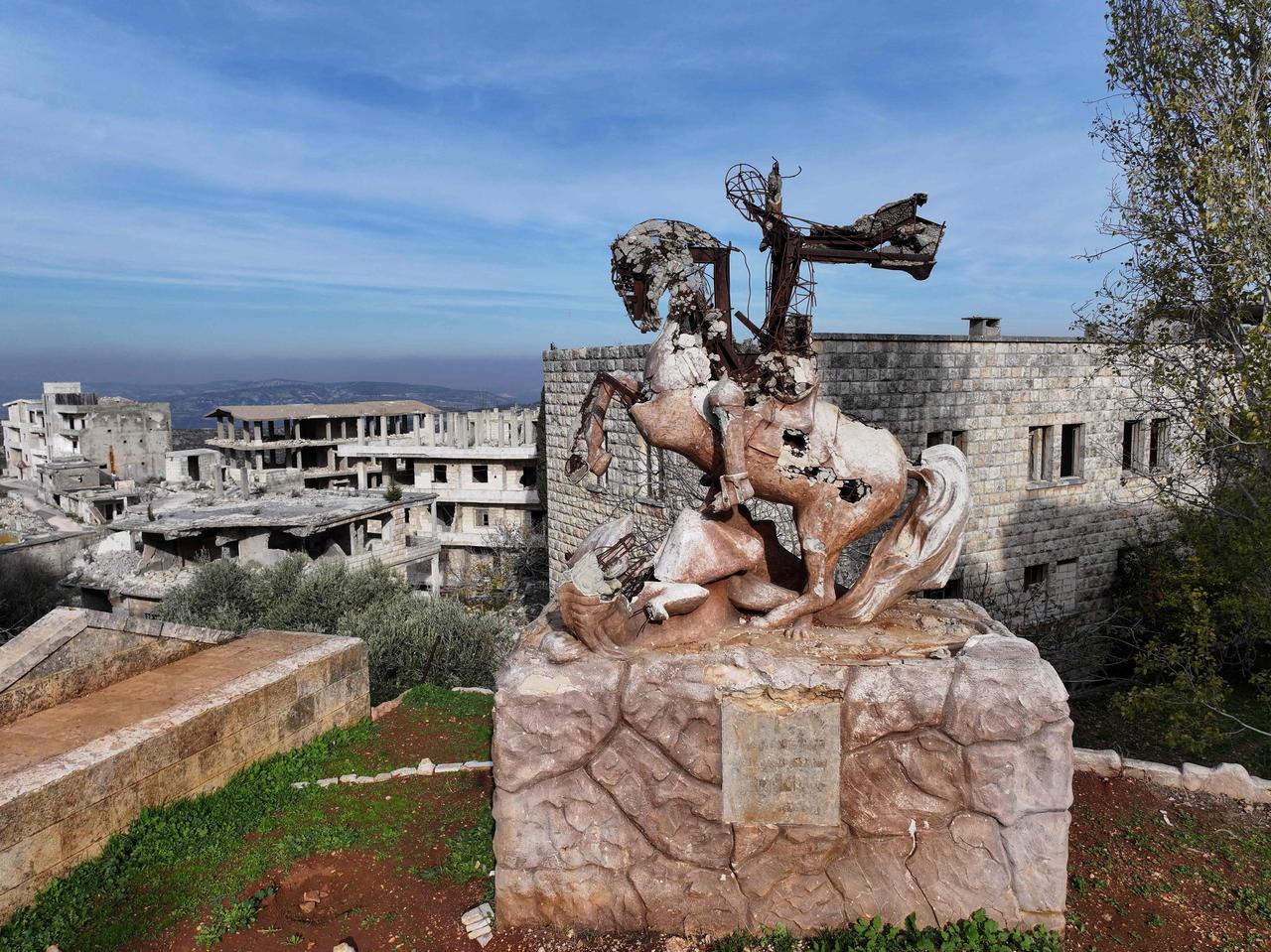 The destroyed statue of Saint George and The Dragon remains in al-Ghassaniya, a mainly Christian town in central Syria, as it residents begin to return to their destroyed homes and businesses after they fled during the Syrian civil war, on December 2025. (AFP Photo)