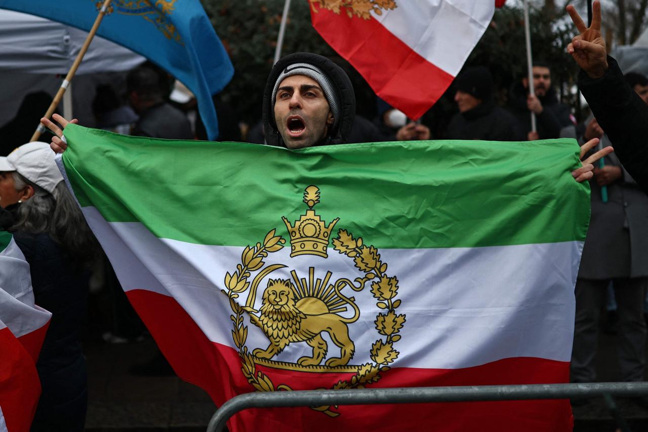 Protester holds the Iranian flag before the 1979 revolution with the Lion and Sun emblems during a gathering outside the Iranian Embassy, central London, Britain, Jan. 9, 2026. (AFP Photo)