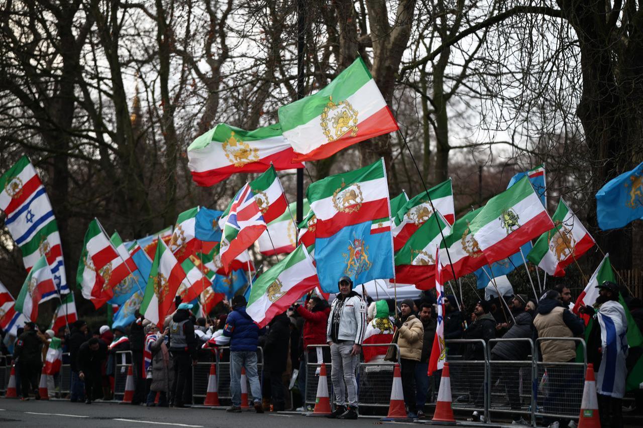 Anti-Iranian regime protesters wave the Iranian flag before the 1979 revolution with the Lion and Sun emblems and Israeli flags during a gathering outside the Iranian Embassy, central London, on Jan. 9, 2026. (AFP Photo)