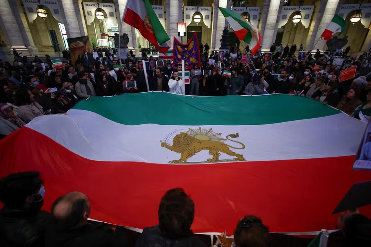 People hold the "Lion and Sun" pre-Iranian Revolution national flag during a rally in support of nationwide protests in Iran, in Rome, Italy, Jan. 13, 2026. (Photo via Iran INT)