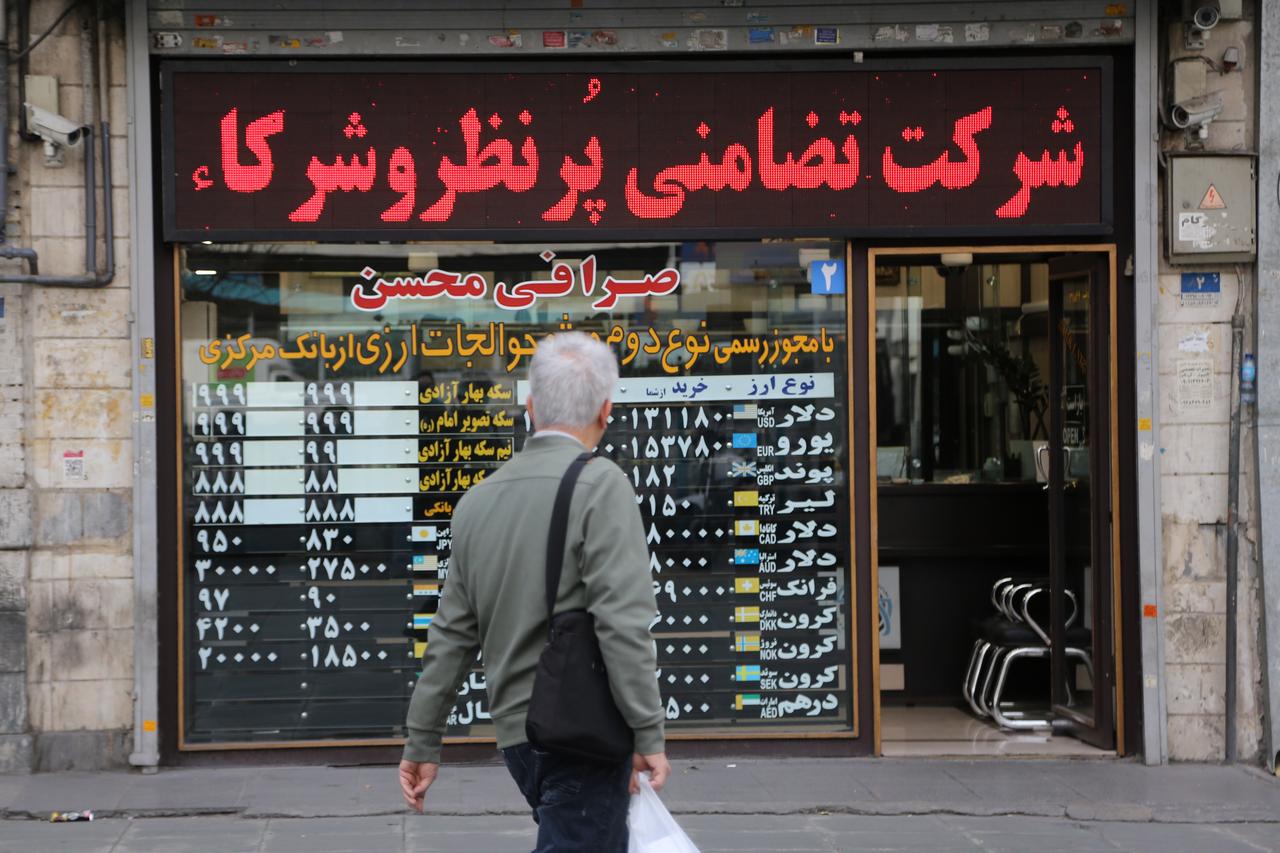 People walk past currency exchange offices on Ferdowsi Street as the offices have not yet returned to normal operations in Tehran, Iran on Jan. 15, 2026. (AA Photo)