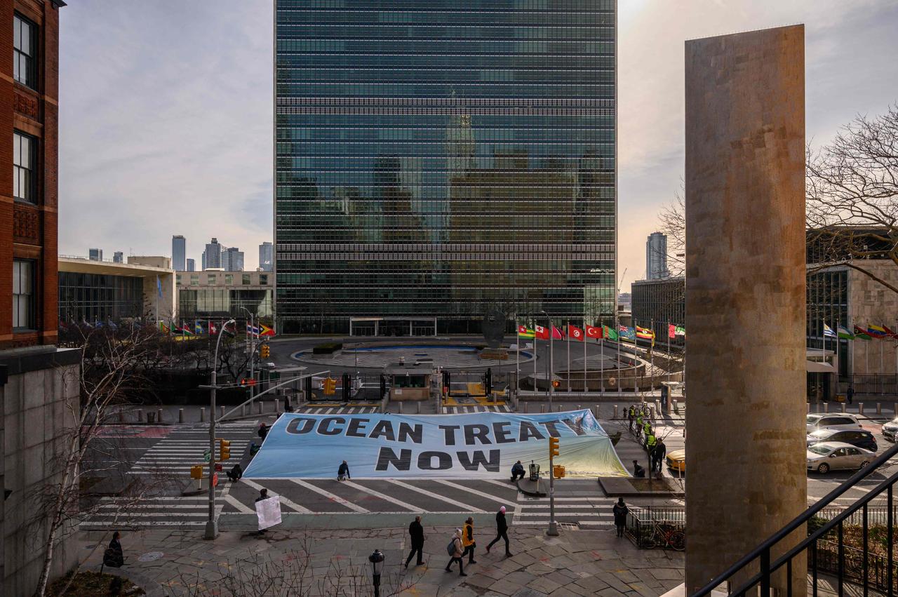 Activists from Greenpeace display a banner before the United Nations headquarters during ongoing negotiations at the UN on a treaty to protect the high seas in New York, United States on Feb. 27, 2023. (AFP Photo)